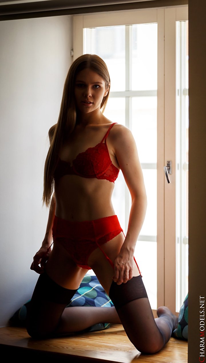 Evelina on the window in red lingerie
