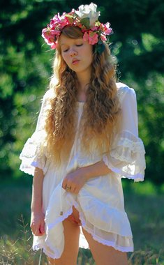 Charming redheaded girl Dolly Little holds a parasol while getting naked